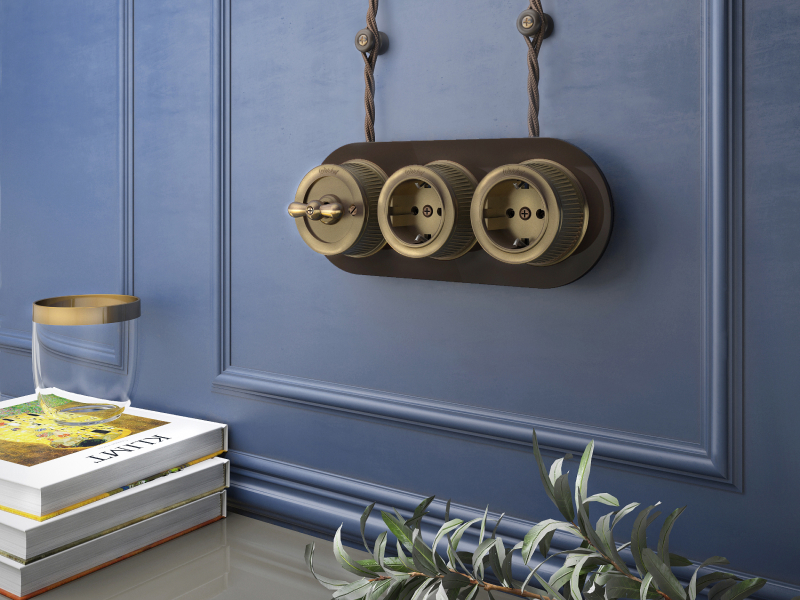 В данном случае бронзовые розетки и выключатель отлично сочетаются с глубоким синим цветом стен